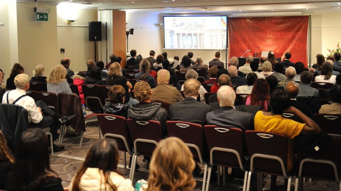 PAC London guests seated and watching video before Mr. Flurry's lecture