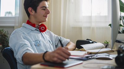 Young teenager from home doing their work or exercise for the exam, deals with graphic design and works in the program Photoshop.