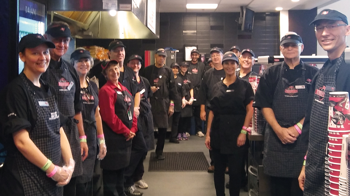 ACT SE fundraising activity, group shot in aprons and visors 