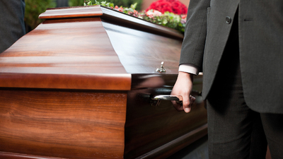 Dolor - Funeral with coffin on a cemetery, the casket carried by coffin bearer