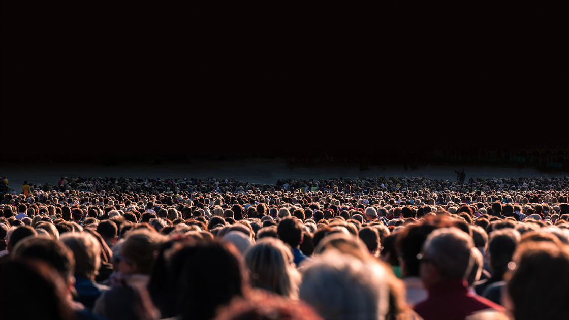 Panoramic photo of large crowd of people. Slow shutter speed motion blur.