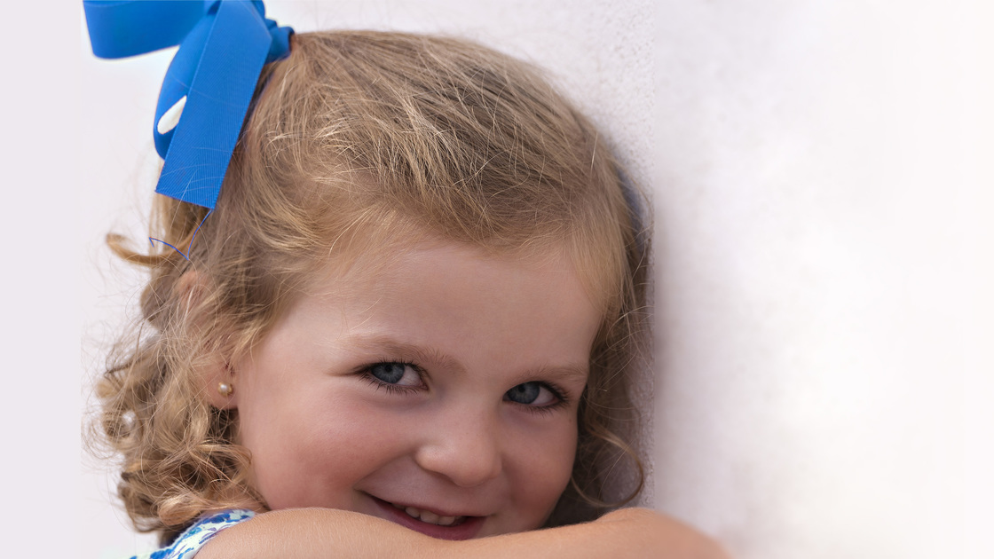 Girl smiling against a wall