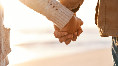 Cropped shot of an unrecognizable couple holding hands on the beach