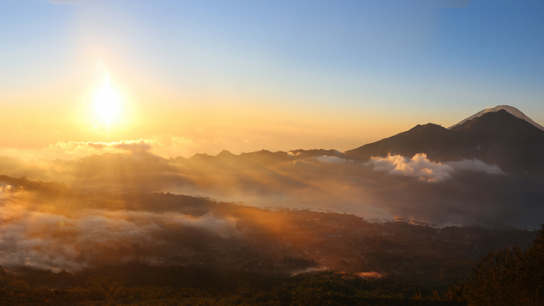 Image of Mount Agung volcano in Bali, photographed in the sunrise from the top of another volcano - Mount Batur. Beautiful sunrise above the clouds in the dawn.