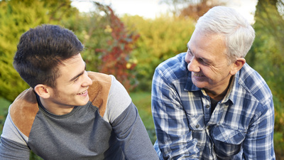 father and teenage son enjoying each others company in the garden