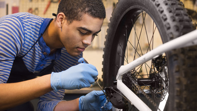 young mechanic fixing some gears on a bike