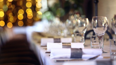 Formal wedding place setting on long table background focus on wine glass