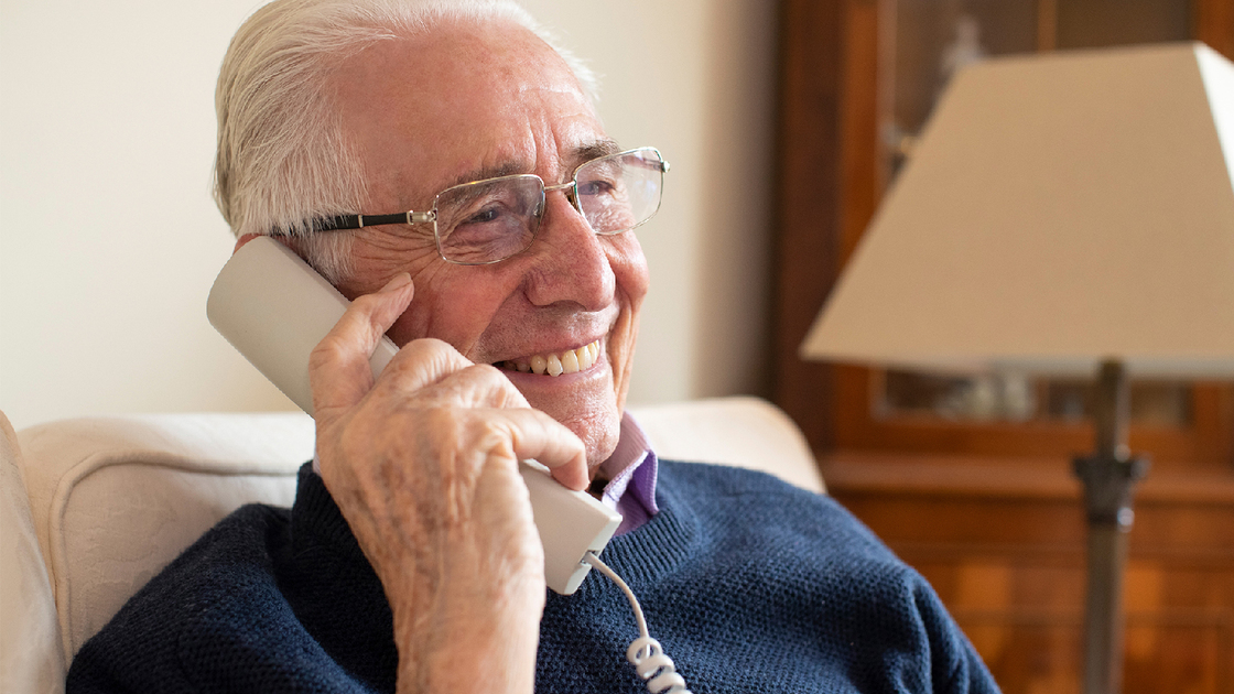 Smiling Senior Man Using Phone At Home