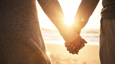 Rearview shot of an unrecognizable couple holding hands while at the beach
