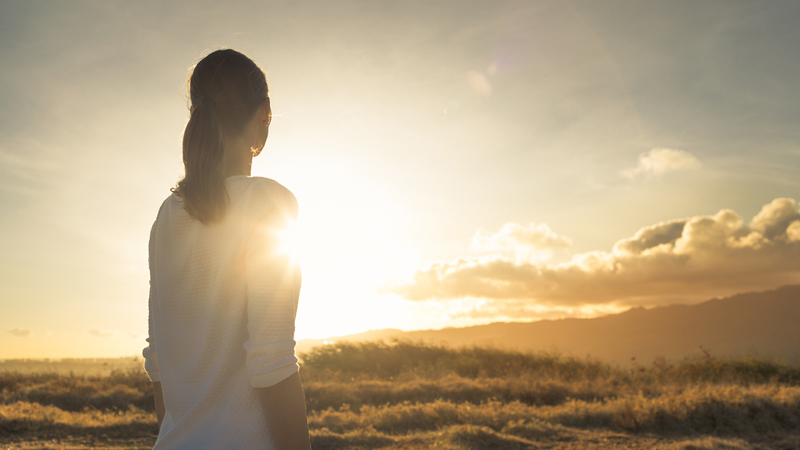 Woman looking at the sunset. Location Hawaii.