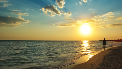 beautiful sunset on the beach and walk man silhouette