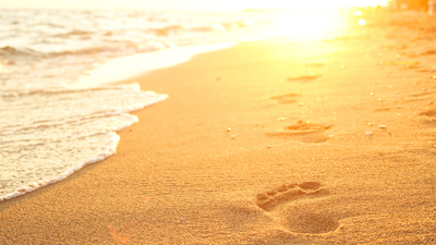 Footprints in the sand at sunset.