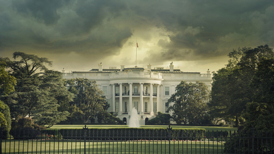 The White House in Washington DC under dark stormy clouds