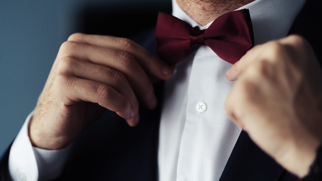 Grooms suit close up detail, groom wearing black suit in the wedding day with a flower attached