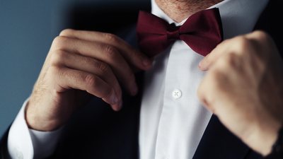 Grooms suit close up detail, groom wearing black suit in the wedding day with a flower attached