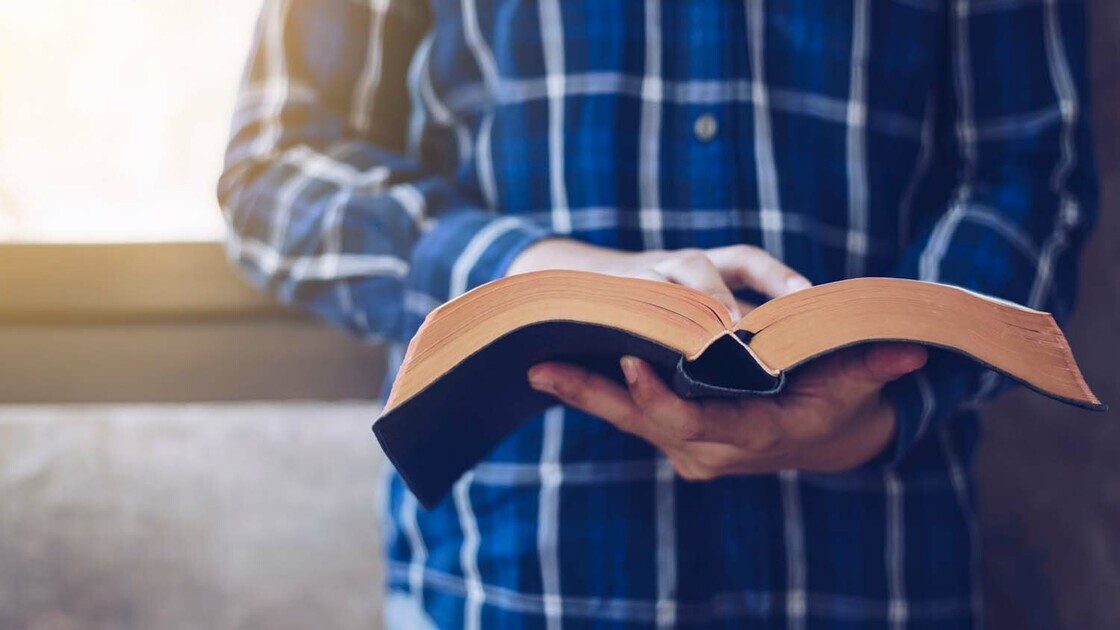 Bible and man in blue plaid reading it?