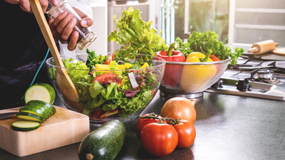 Young happiness Woman Cooking vegetables salad in the kitchen, Healthy food concept.