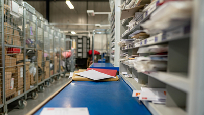 Letters on a sorting frame, table and shelves in a mail delivery sorting centre. Postal service, post office inside
