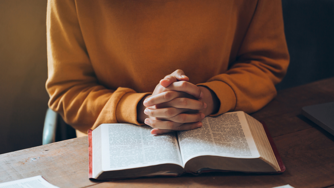 Woman hands praying on the Bible. 