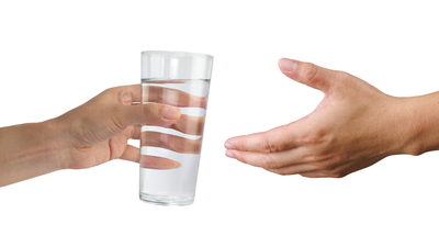 Hand holding a glass of water isolated on white background