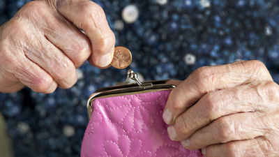 Penny being deposited or pulled out of a purse by a pair of elderly hands.