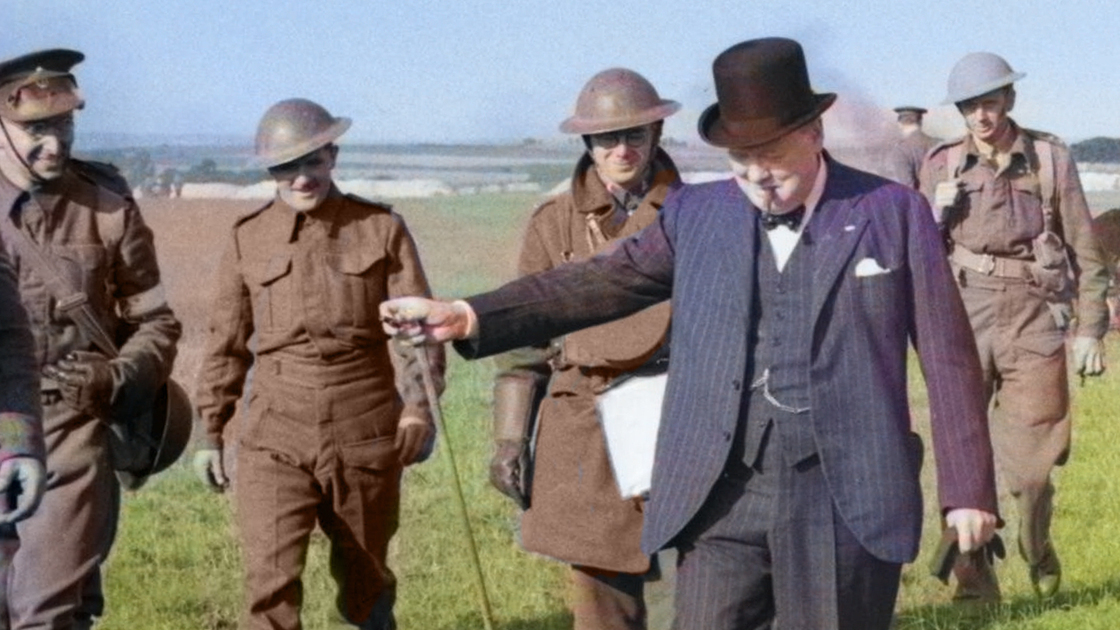 Winston Churchill and his entourage walk away from the crash-site of a Messerschmitt Bf 109E on Church Farm at Church Whitfield near Dover, 28 August 1940. Churchill was travelling between Dover and Ramsgate at the time, touring invasion defences, when the German aircraft was shot down. He ordered his car to halt and walked over to view the wreckage, much to the consternation of his personal bodyguard, Inspector W H Thompson (seen here on the right), as German aircraft were still in the vicinity.