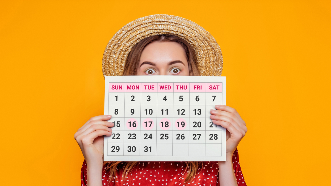 Shocked girl holding a sheet of paper with a monthly cycle calendar. Delayed menstruation in a woman