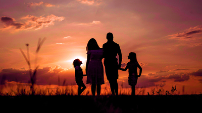 Family in a field with beautiful sunset in the background