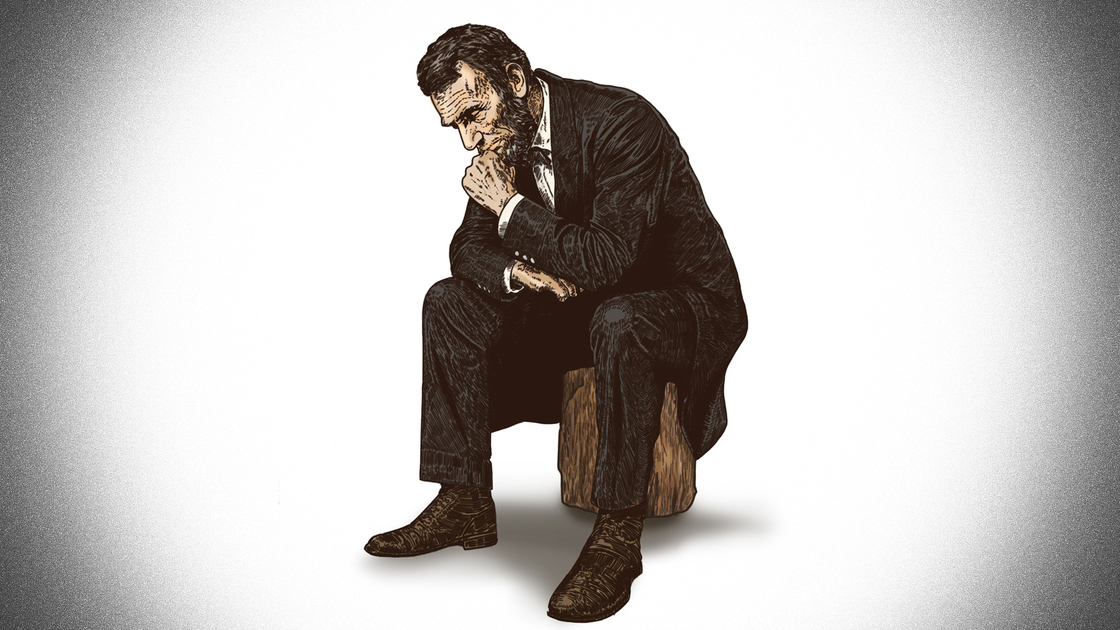 Abraham Lincoln in deep thought while sitting on a log