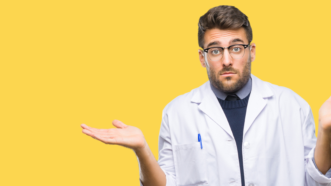 Young handsome man wearing doctor, scientis coat over isolated background clueless and confused expression with arms and hands raised. Doubt concept.